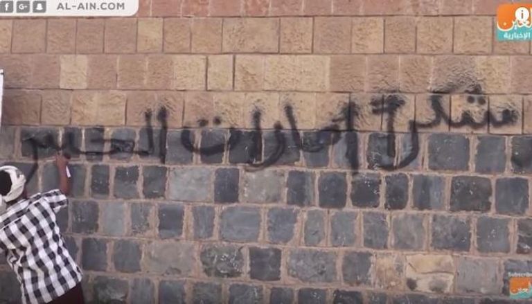 شاب يمني يكتب على جدار عبارة "شكرا إمارات الخير"
