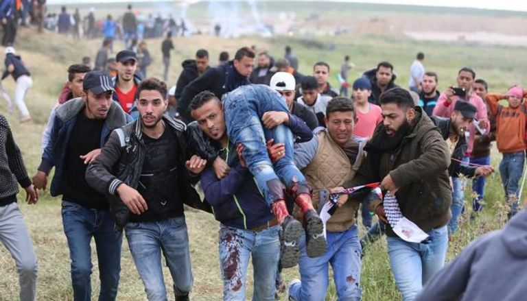 فلسطينيون يحملون مصابا جراء إطلاق نار من قبل قوات الاحتلال