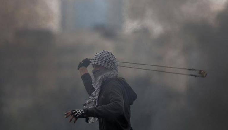 شاب فلسطيني يواجه قنابل الغاز خلال مسيرة العودة