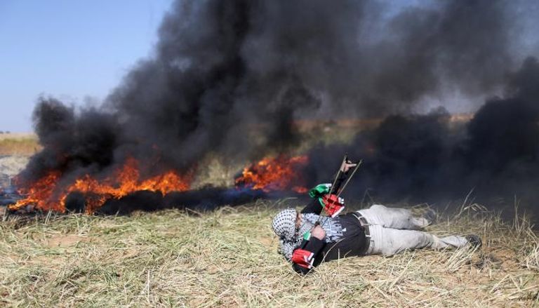 فلسطيني يرشق قوات الاحتلال بالحجارة في غزة