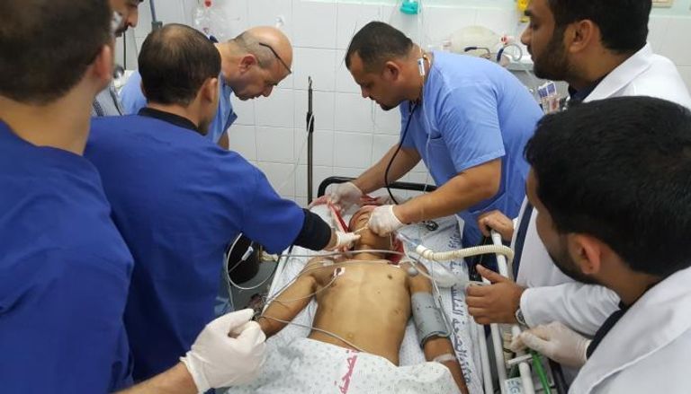أطباء فلسطينيون يحاولون إسعاف الطفل المصاب تحرير محمود أبوسبلة