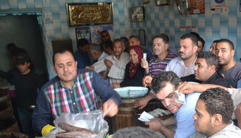 مواطنون يشترون أسماك الفسيخ من أحد محلات مدينة نبروه