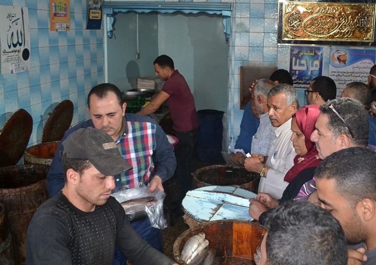 مواطنون يشترون أسماك الفسيخ من أحد محلات مدينة نبروه