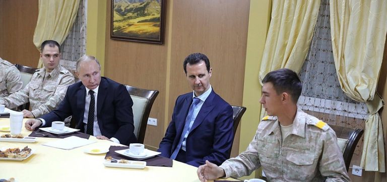 الأسد في قاعدة حميميم مع بوتين خلال زيارة سابقة للأخير قاسم سليماني قائد مليشيات إيران خلال تواجده بسوريا (أرشيف)