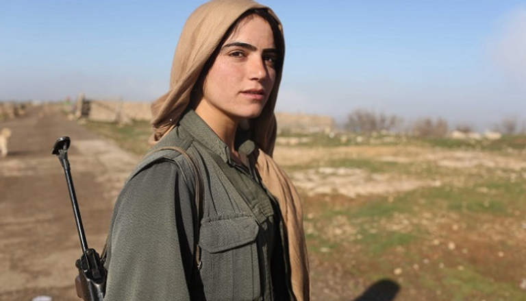 مقاتلة من وحدات حماية المرأة تقف في نقطة مرتفعة بجبل سنجار