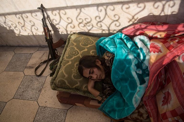 مقاتلة من وحدات حماية المرأة تقف في نقطة مرتفعة بجبل سنجار