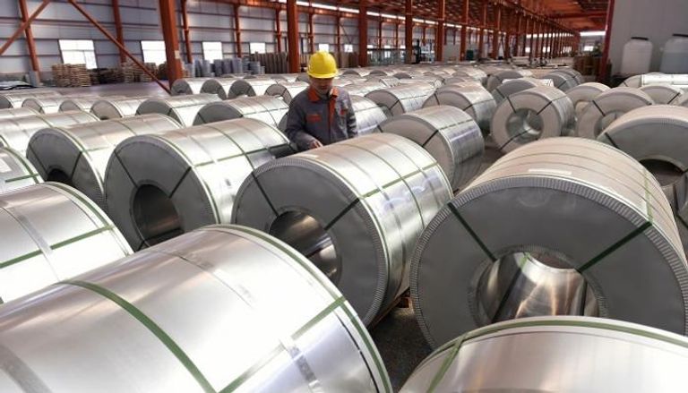 عامل يتفقد بكرات الألومنيوم في أحد المصانع شرق الصين