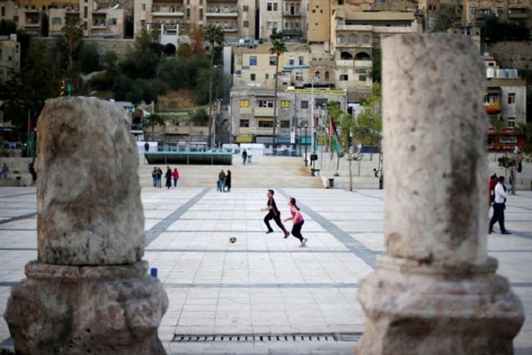 أطفال يلعبون كرة القدم في منطقة المدرج الروماني  منطقة المدرج الروماني في وسط مدينة عمان - رويترز
