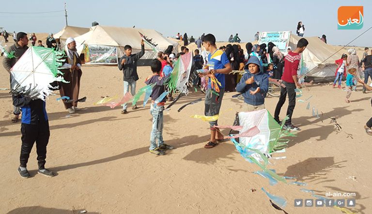 شبان فلسطينيون خلال إعداد الطائرات الحارقة الطائرة الورقية الحارقة حاملة إحدى الرسائل للاحتلال