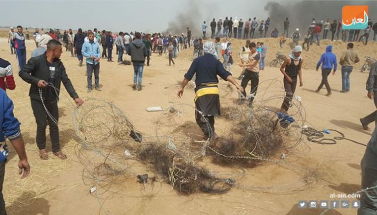 متظاهرون ينزعون السلك الشائك قرب الحدود مع إسرائيل