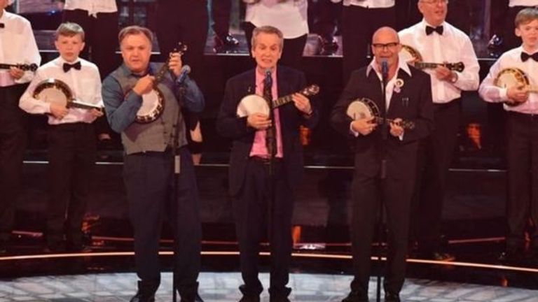 نائب حزب العمال السابق، إد بولز (على اليسار) والمذيع فرانك سكينر والكوميدي هاري هيلز قدموا عرضا بآلة الأوكلال على خشبة المسرح الملكة إليزابيث تحتفل بعيد ميلادها بقاعة ألبرت الملكية