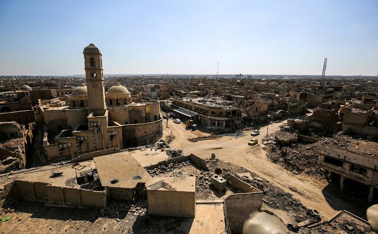 مواطنان عراقيان يتجولان في أحد شوارع الموصل المدمرة - رويترز