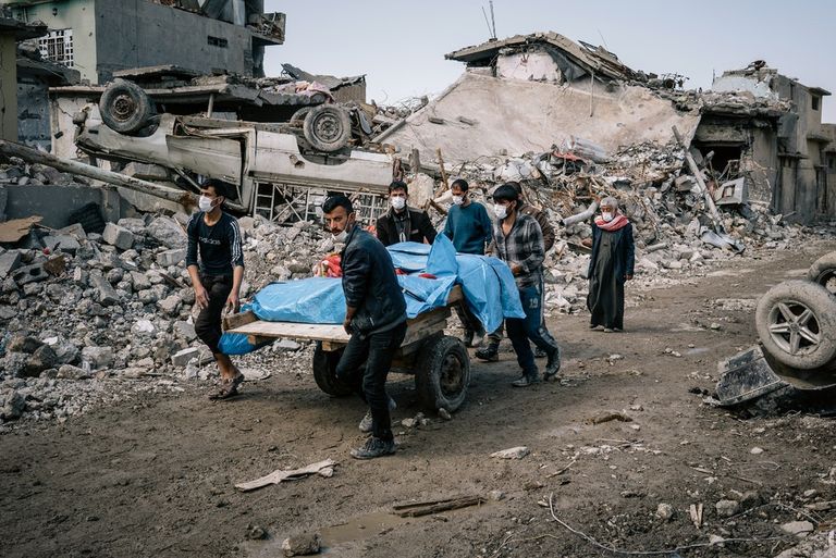 مواطنان عراقيان يتجولان في أحد شوارع الموصل المدمرة - رويترز