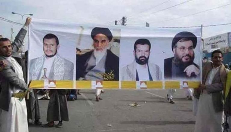 حوثيون موالون لإيران يرفعون لافتة بصور خوميني إيران والحوثي ونصرالله