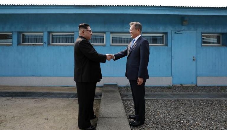 كيم ومون يتصافحان عند الخط الفاصل بين الكوريتين - أ.ف.ب
