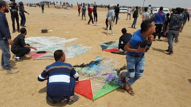 مجموعة من الشبان خلال إعداد الطائرات الورقية المحملة بعبوات حارقة قوات الاحتلال تطلق الرصاص الحي على الشبان الفلسطينيين