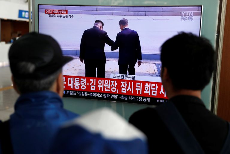 كوريون يتابعون لقاء الزعيمين زعيما الكوريتين أثناء لقائهما