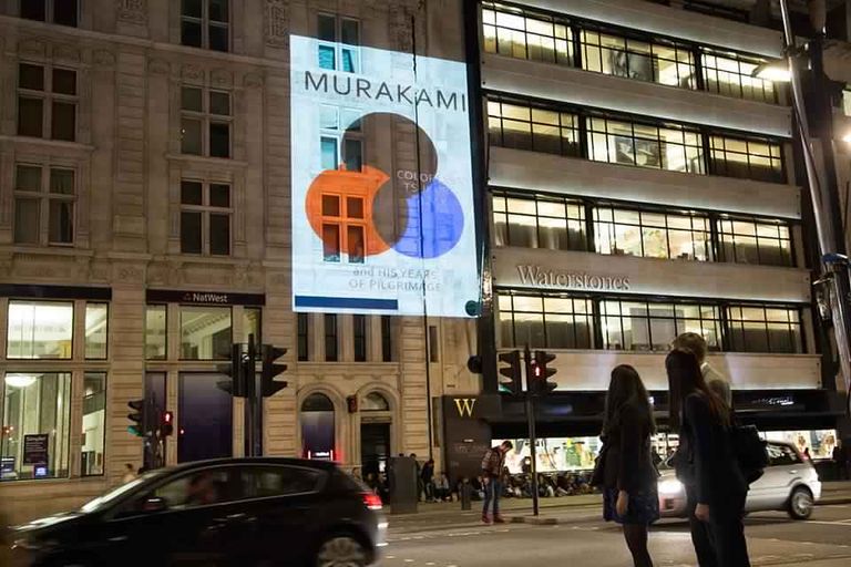  جمهور موراكامي يلتقطون صورا مع إحدى إصداراته فور طرحها بالمكتبات