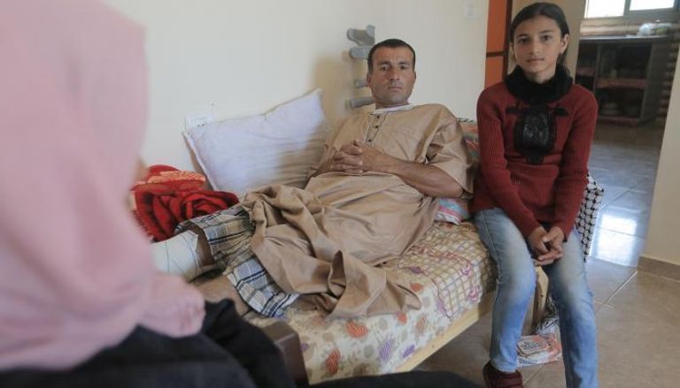  ريهام القديح (14 عاماً) مع والدها المصاب