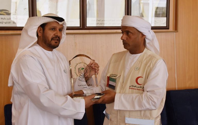 حمد العامري يقبل بعض أطفال اللاجئين في المخيم