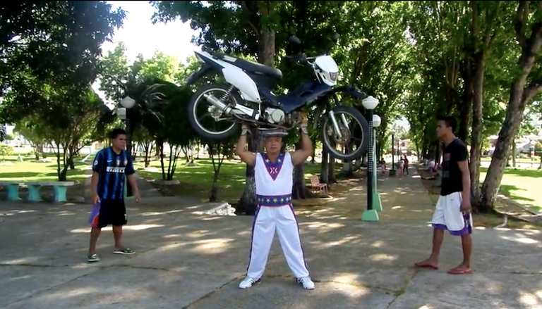 شاب يقود دراجة نارية واقفا