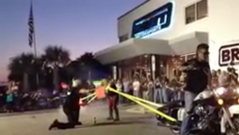 شاب يقود دراجة نارية واقفا