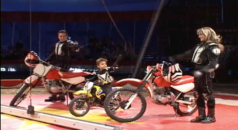 شاب يقود دراجة نارية واقفا