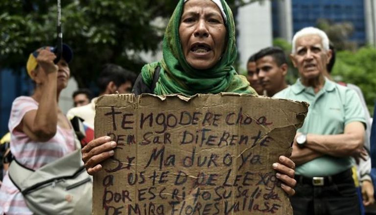 أمرأة تحمل لافتة تندد بحكومة فنزويلا في العاصمة كاراكاس 