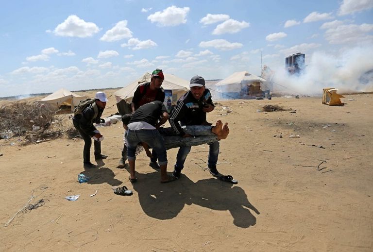 نقل أحد المصابين الفلسطينيين جراء المواجهات مع قوات الاحتلال الشاب أبو حجر يجسد شخصية باتمان في تظاهره ضد قوات الاحتلال