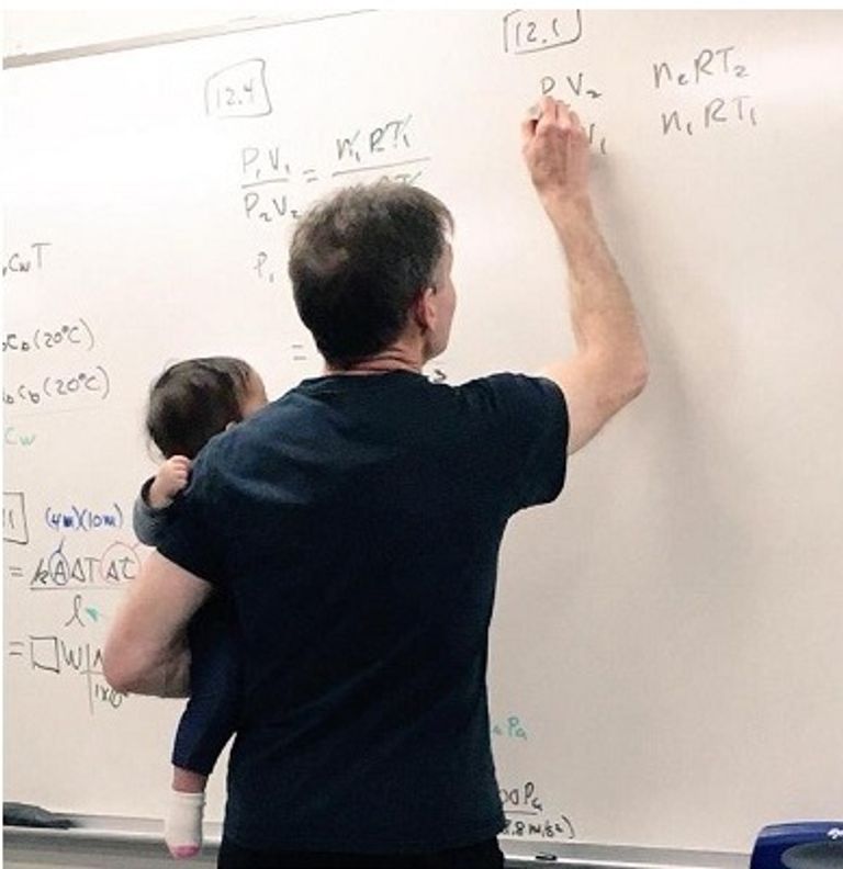 أستاذ جامعي يحمل رضيع إحدى طالباته