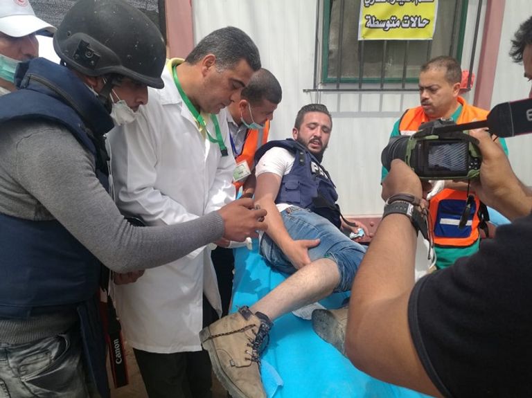 فلسطيني يحمل مصابا خلال الاشتباكات مع قوات الاحتلال