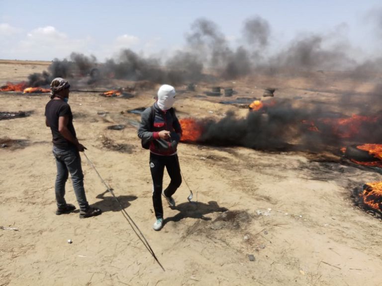 فلسطيني يحمل مصابا خلال الاشتباكات مع قوات الاحتلال