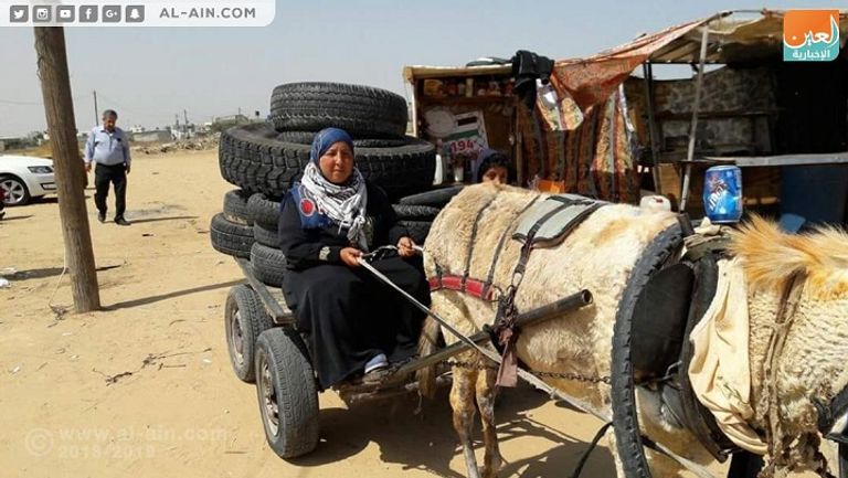 سيدة فلسطينية تجهز الإطارات لتظاهرة جمعة النذير