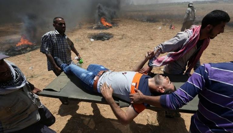 فلسطينيون يحملون أحد المصابين