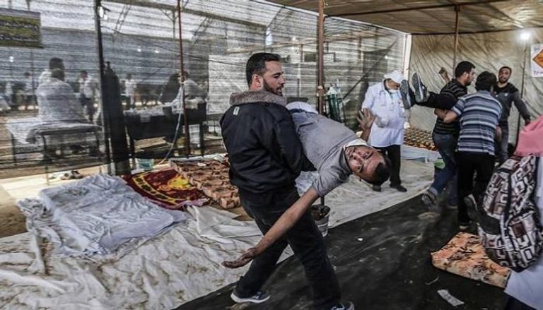 فلسطيني يحمل شهيد قتل برصاص الاحتلال