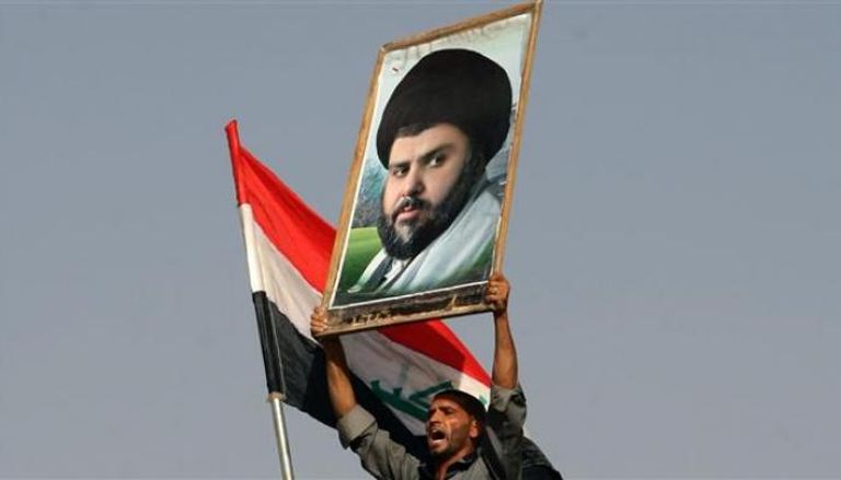 أحد أتباع الزعيم الشيعي مقتدى الصدر يرفع صورته