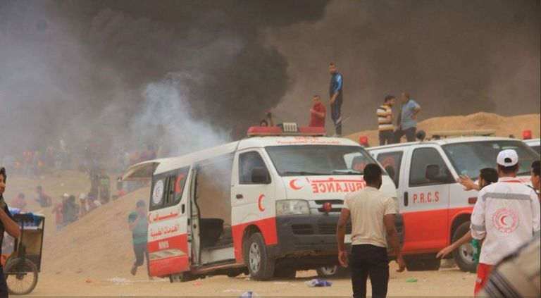 مسعف فلسطيني يعالج زميله الذي أصابته قوات الاحتلال الإسرائيلي