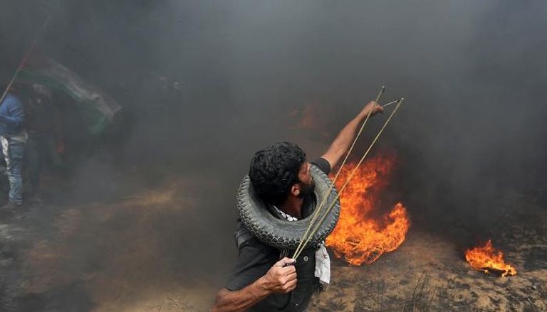 شاب فلسطيني يفلت حجارته تجاه قوات الاحتلال في غزة