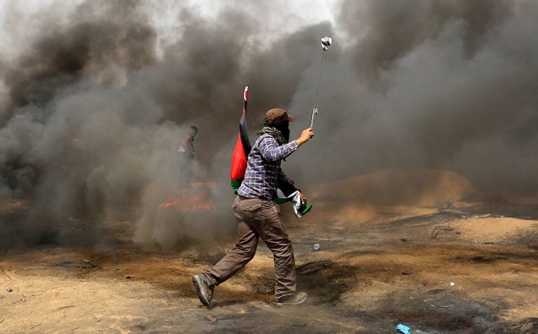 شاب فلسطيني يحاول رمي قوات الاحتلال بالحجارة شرق غزة شاب فلسطيني يفلت حجارته تجاه قوات الاحتلال في غزة