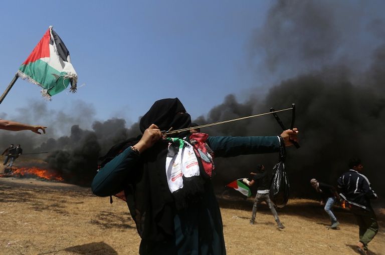 فتاة فلسطينية تشارك في تظاهرة حق العودة في غزة شاب فلسطيني يفلت حجارته تجاه قوات الاحتلال في غزة