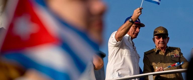 رئيس كوبا يلوح بعلم بلاده إلى جانب الرئيس السابق راؤول كاسترو  سيارة قديمة تسير بأحد شوارع العاصمة الكوبية هافانا - رويترز