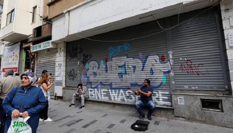 عازف أمام متجر مغلق في شارع التسوق الرئيسي وسط إسطنبول - رويترز