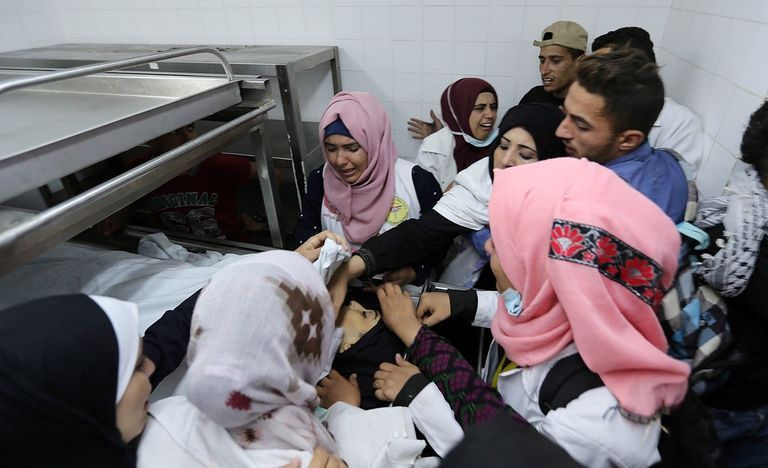 صورة لجثمان الشهيدة محاط بزملائها وأقاربها الشهيدة رزان النجار أثناء إسعاف المصابين خلال مسيرات العودة