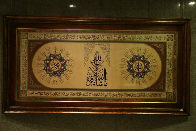 الفنان حسن حسوبة أمام إحدى لوحاته