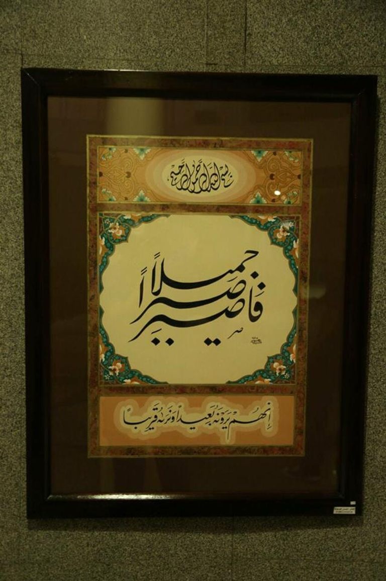 الفنان حسن حسوبة أمام إحدى لوحاته
