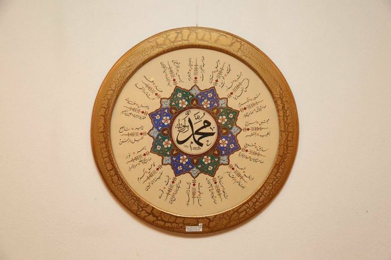 الفنان حسن حسوبة أمام إحدى لوحاته