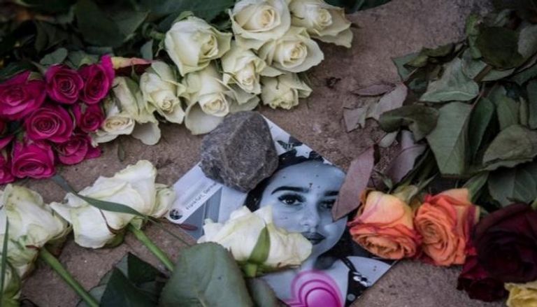 صورة لسوزانا بين الزهور في نصب تذكاري في موقع الاعتداء عليها - أ.ف.ب