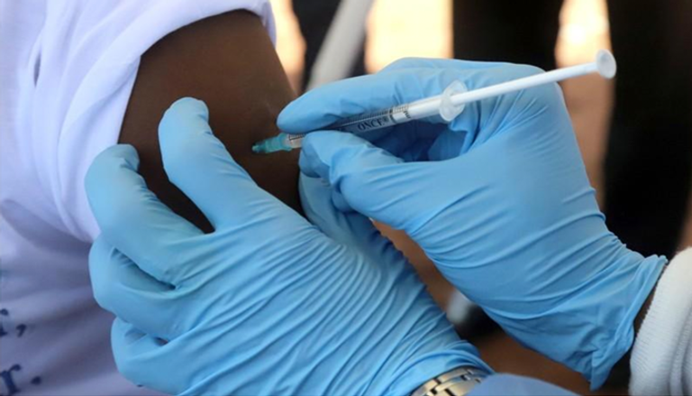  موظف تابع لمنظمة الصحة العالمية يحقن شخصا بتطعيم مضاد للإيبولا