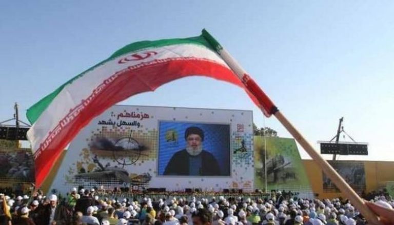 العلم الإيراني مرفوع في مؤتمر لمليشيا حزب الله