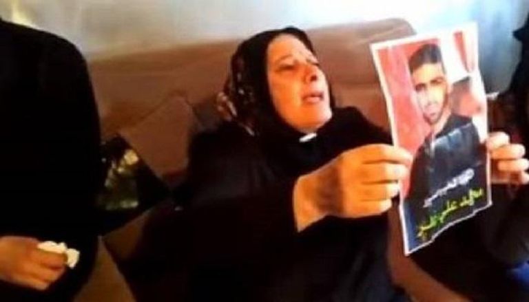 والدة الشاب اللبناني القتيل ترفع صورته 